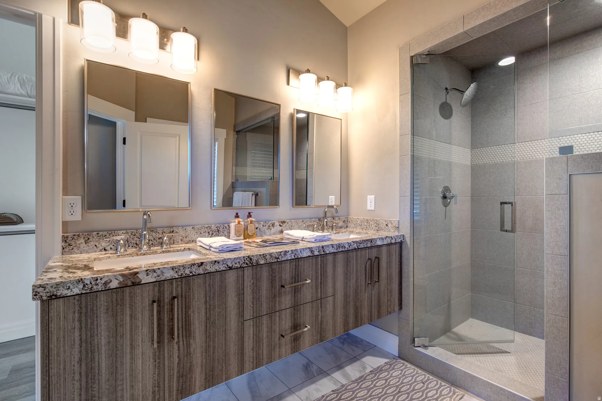 Bathroom featuring a dual vanity with a patterned countertop, dual rectangular sinks, chrome faucets, and individual mirrors
