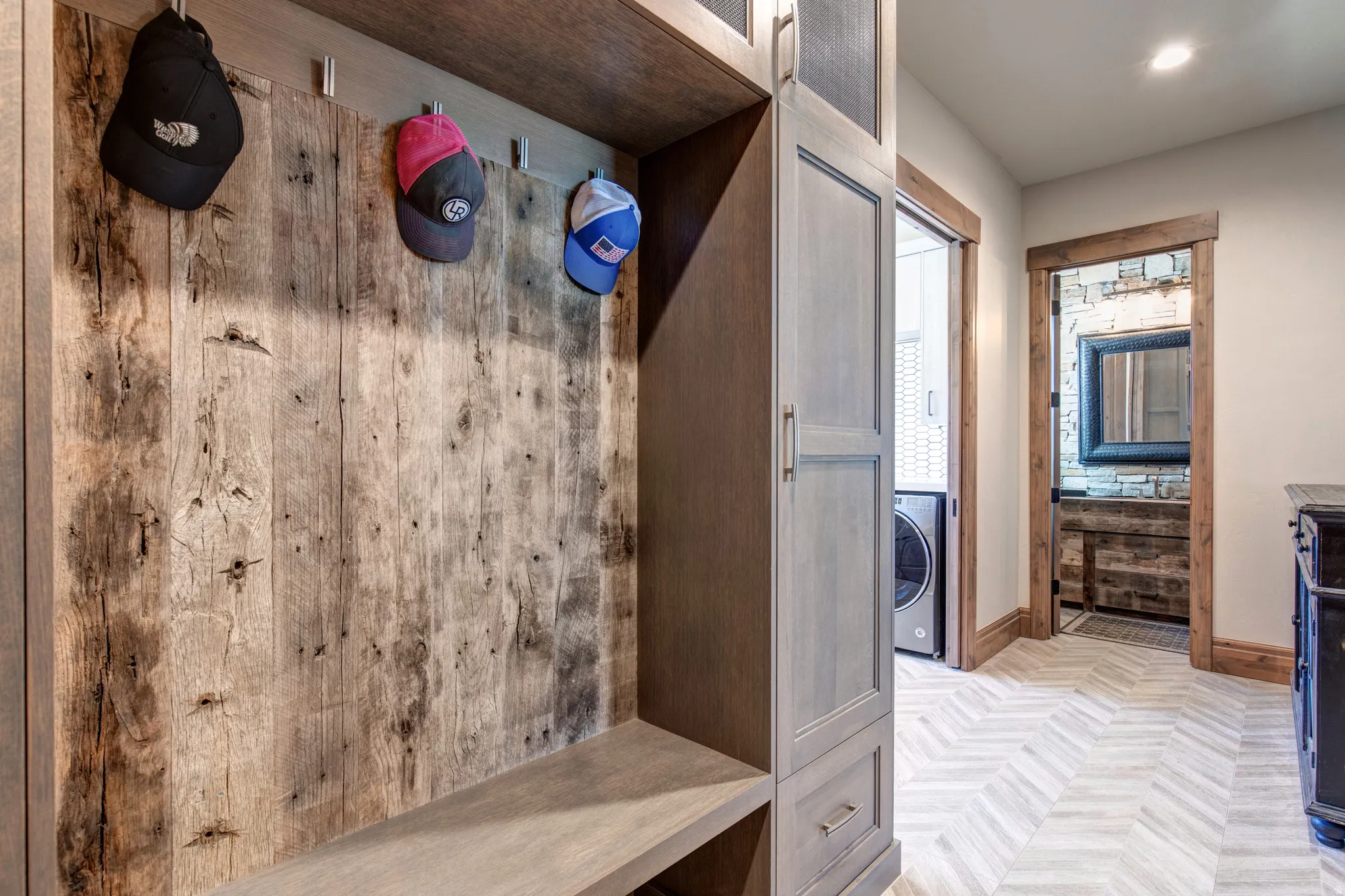Custom built-in entryway organizer featuring a wood-panel accent wall and integrated seating