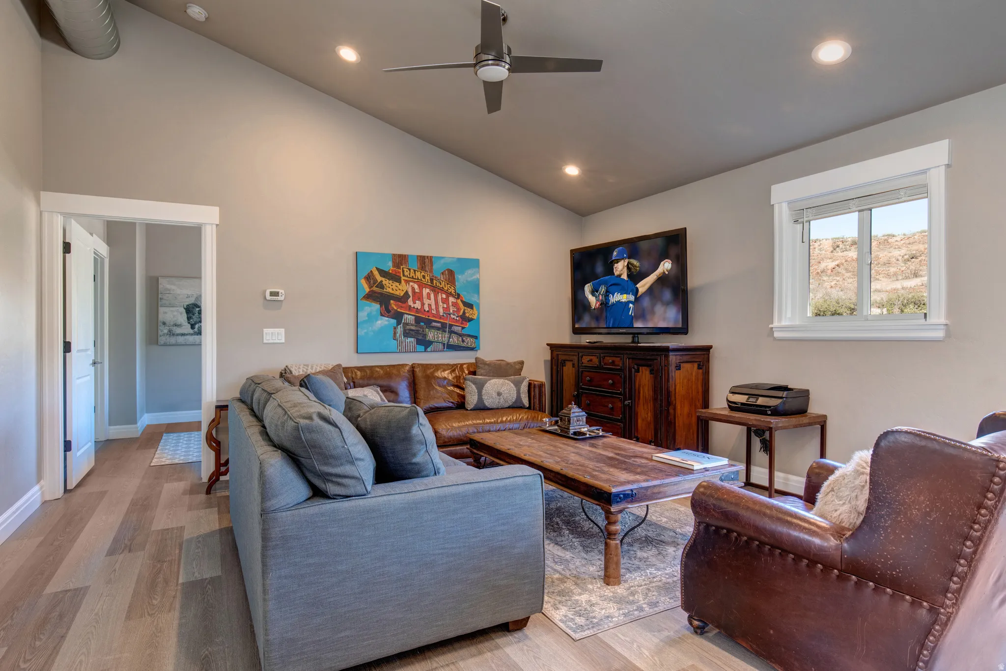 Living area featuring wood-finish flooring, a vaulted ceiling, recessed lighting, and a ceiling fan