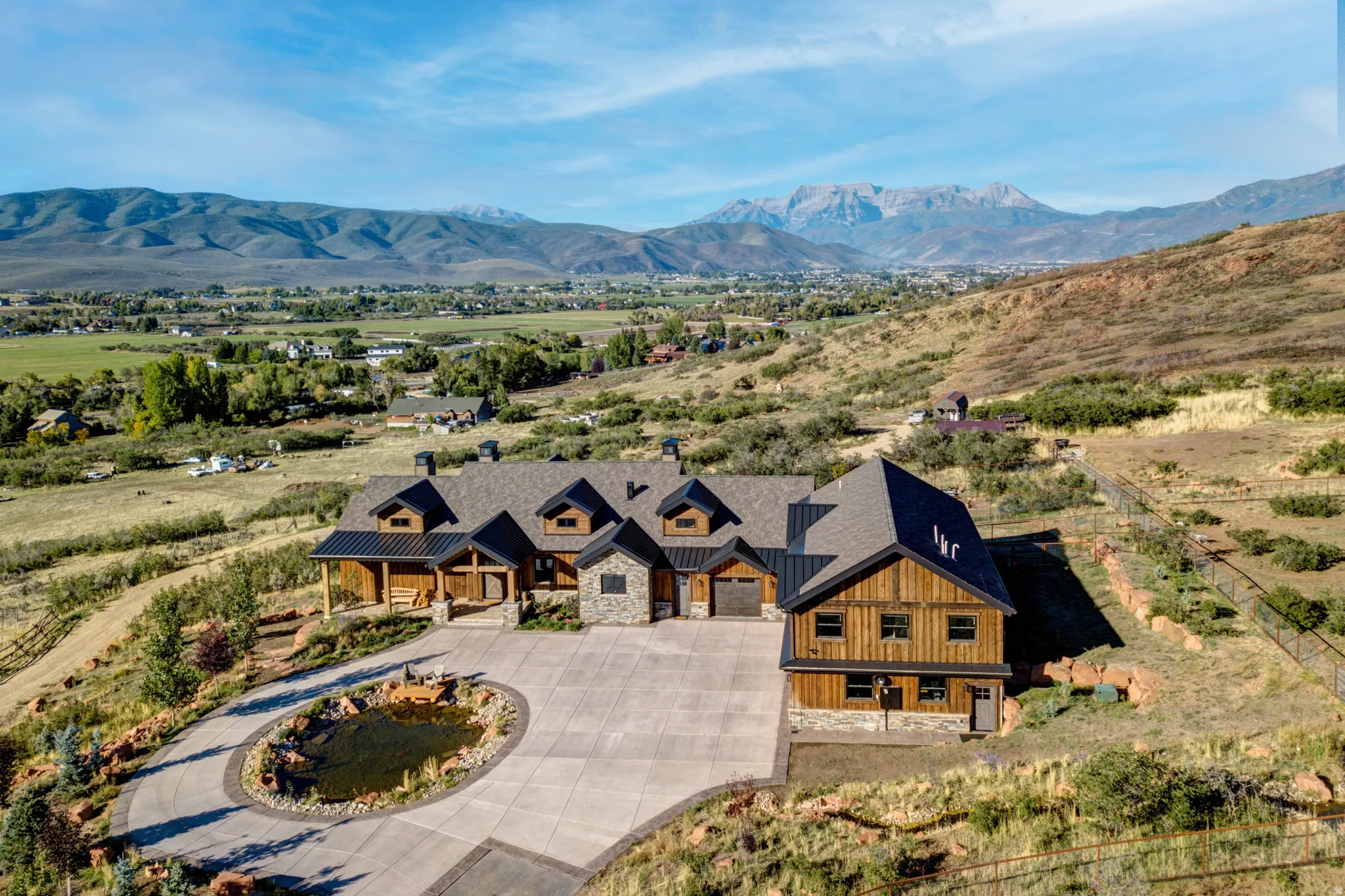 Custom home featuring extensive natural wood siding, stone accents, and a multi-gabled roofline