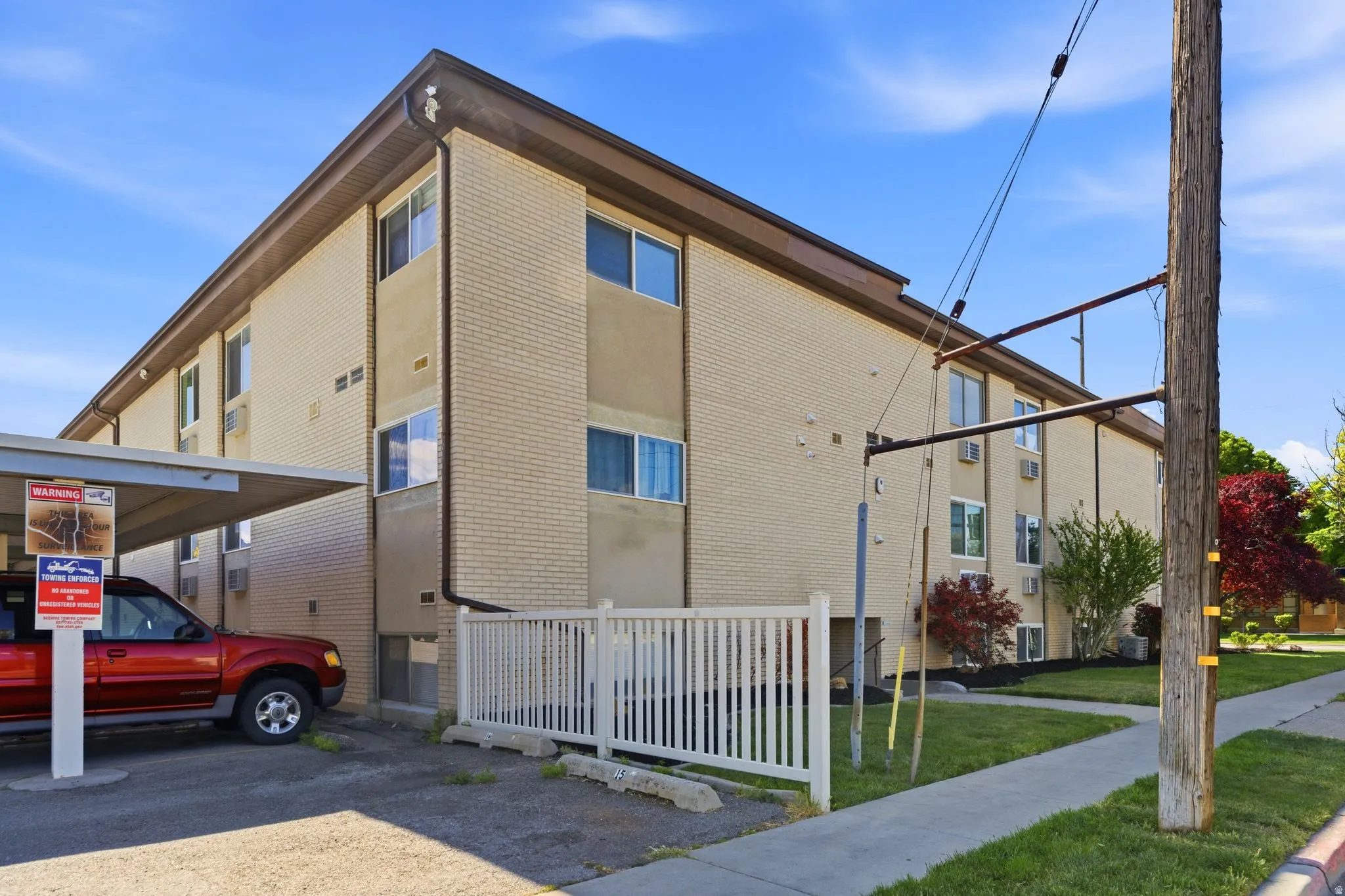 Three-story multi-unit building featuring a brick exterior and a brown roofline