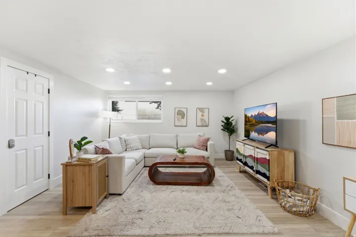 Living area featuring light wood-finish flooring, recessed lighting, and a window with white trim