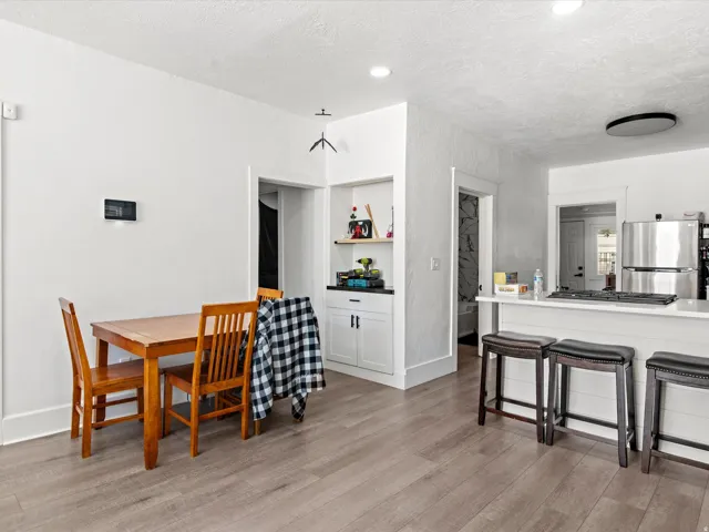 Open-concept living space featuring wood-finish flooring, white walls, and recessed lighting