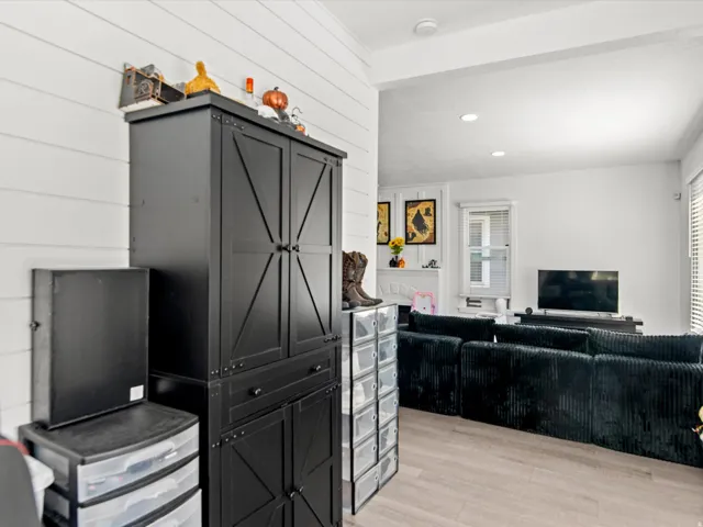 Light wood-finish flooring extending into a bright room with white walls