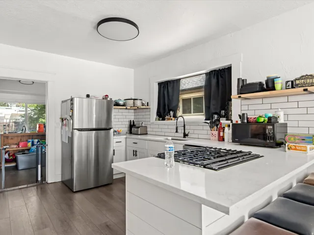 Kitchen featuring white cabinetry, a built-in gas cooktop, light-colored countertops, and white subway tile backsplash