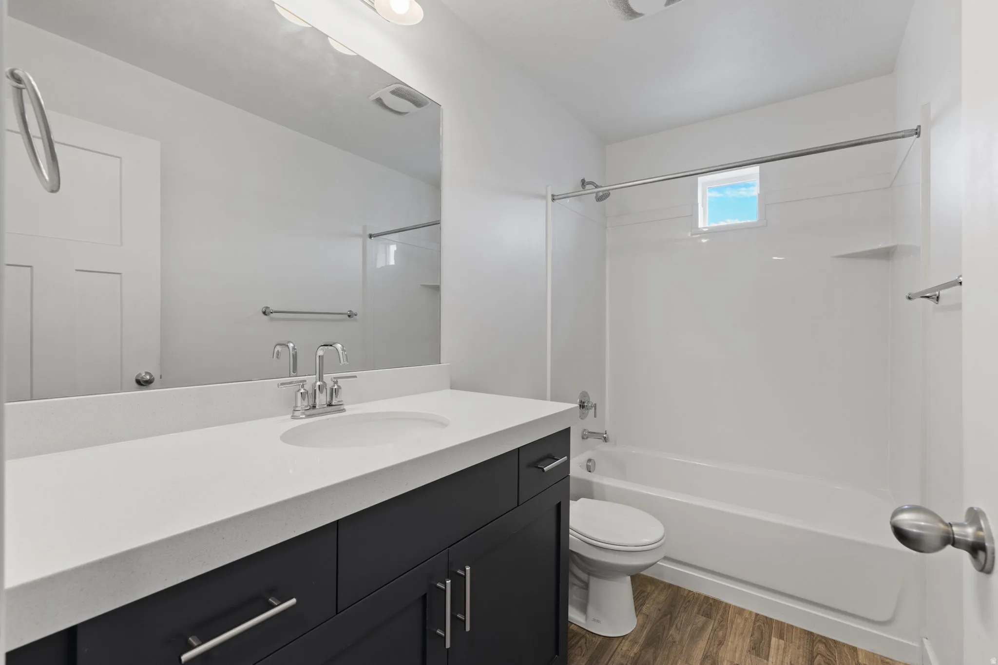 Bathroom featuring a dark wood-finish vanity with a light countertop, a rectangular sink basin, and a chrome faucet