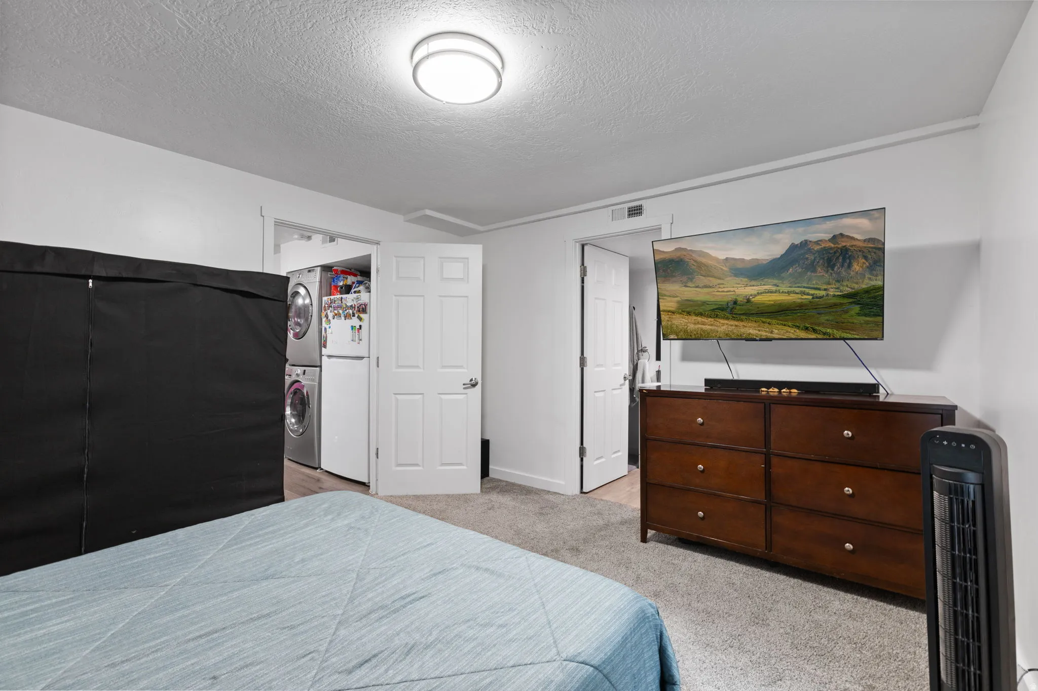 Bedroom featuring light gray carpet, white walls, and a flush-mount ceiling light