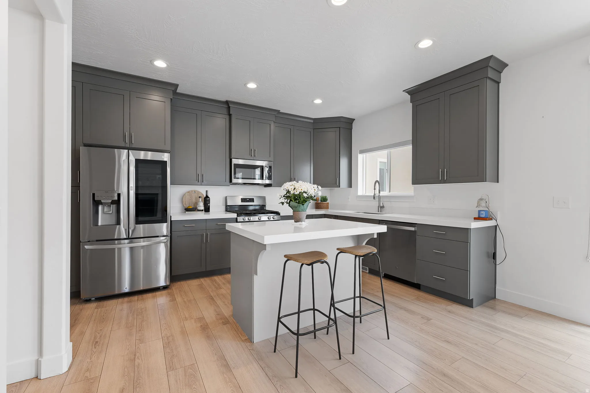 Modern kitchen featuring gray cabinetry and stainless steel appliances