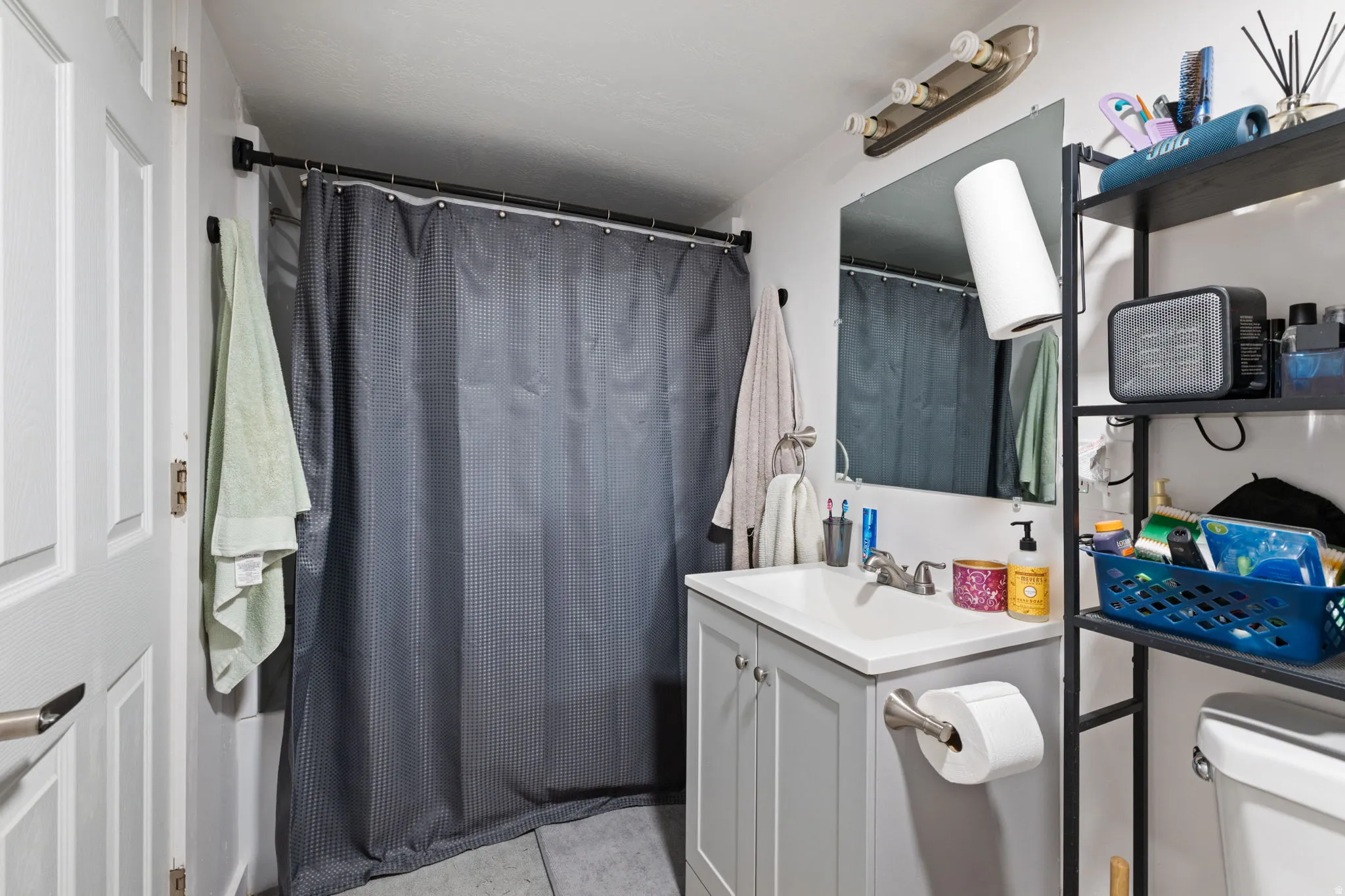 Modern bathroom featuring a single vanity with a white countertop and gray cabinetry