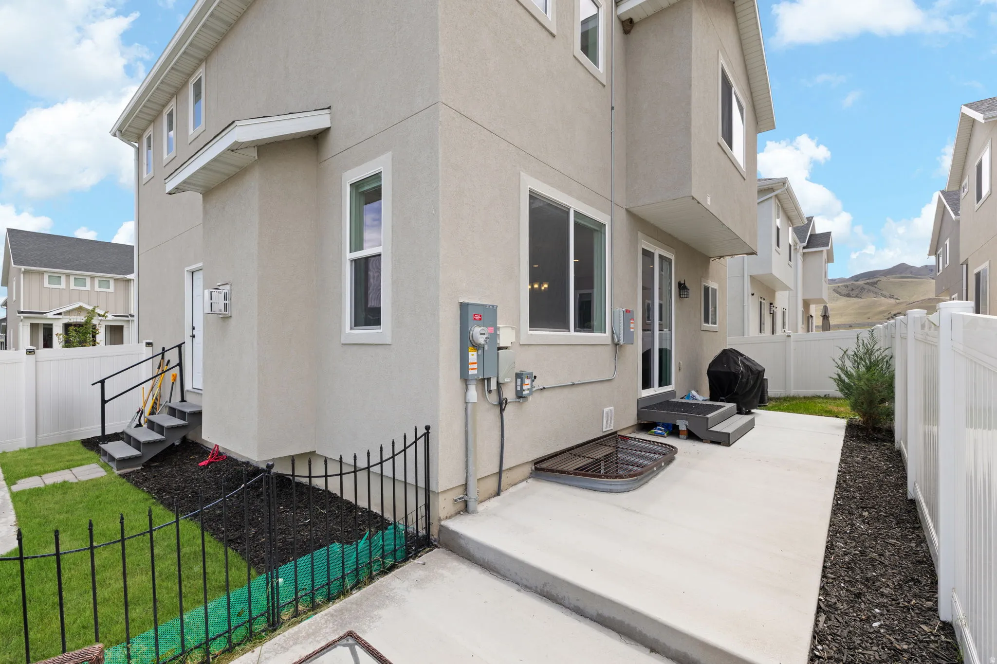 Rear exterior with stucco siding and a concrete patio