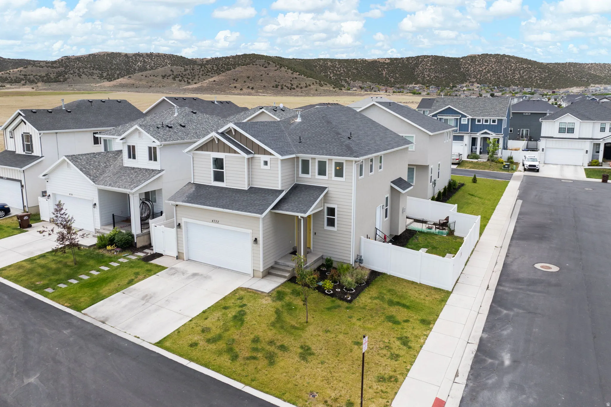 Contemporary two-story residence featuring light beige siding and dark shingle roofing