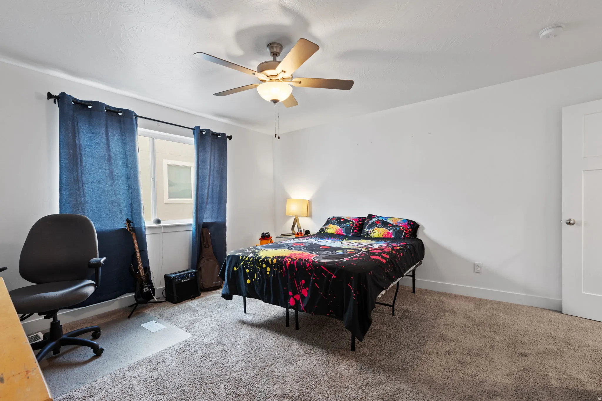 Carpeted room featuring a ceiling fan with integrated lighting, a window with a sill, and a paneled interior door
