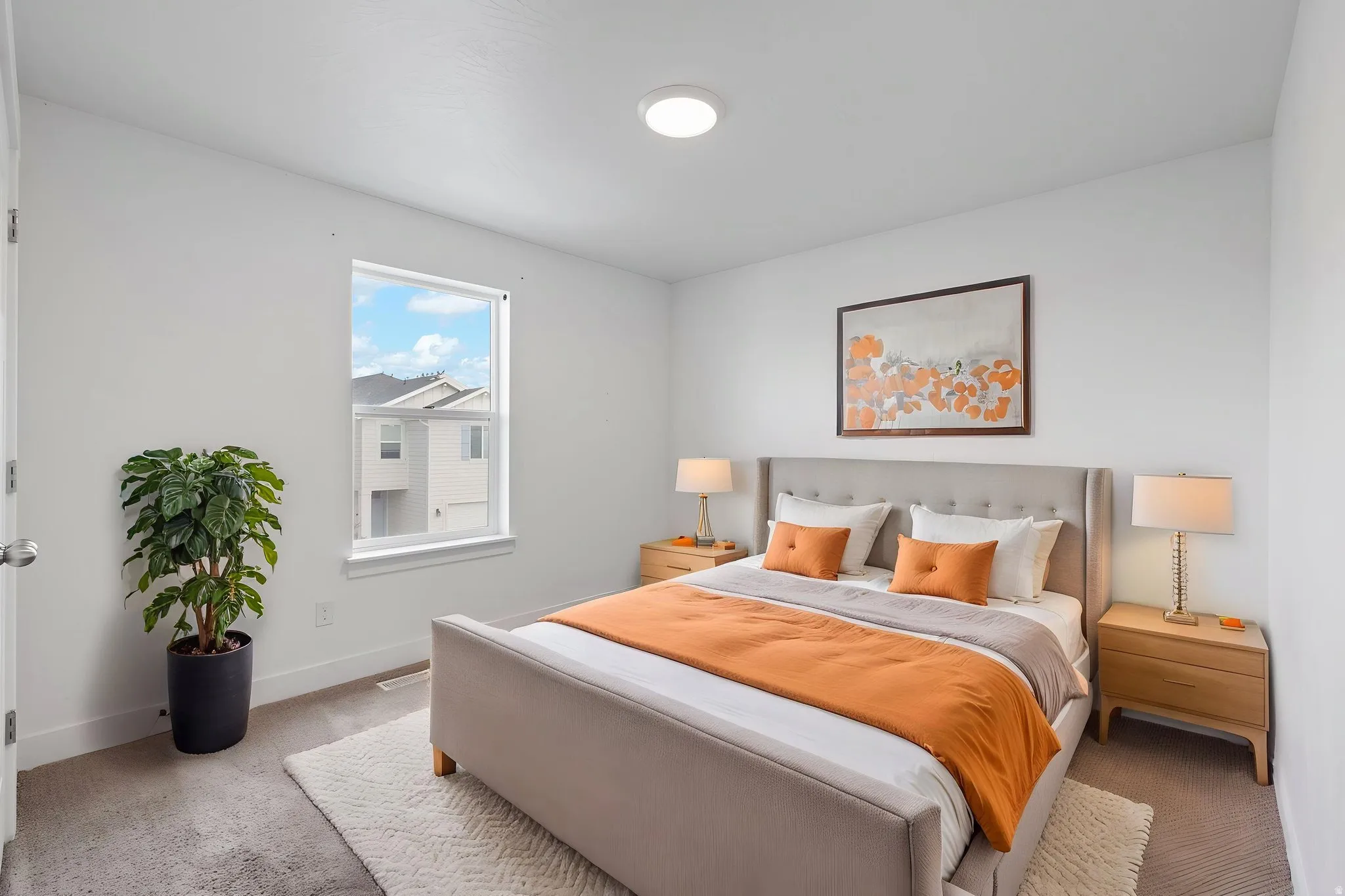Carpeted bedroom featuring a single window, white walls, and a ceiling-mounted light fixture