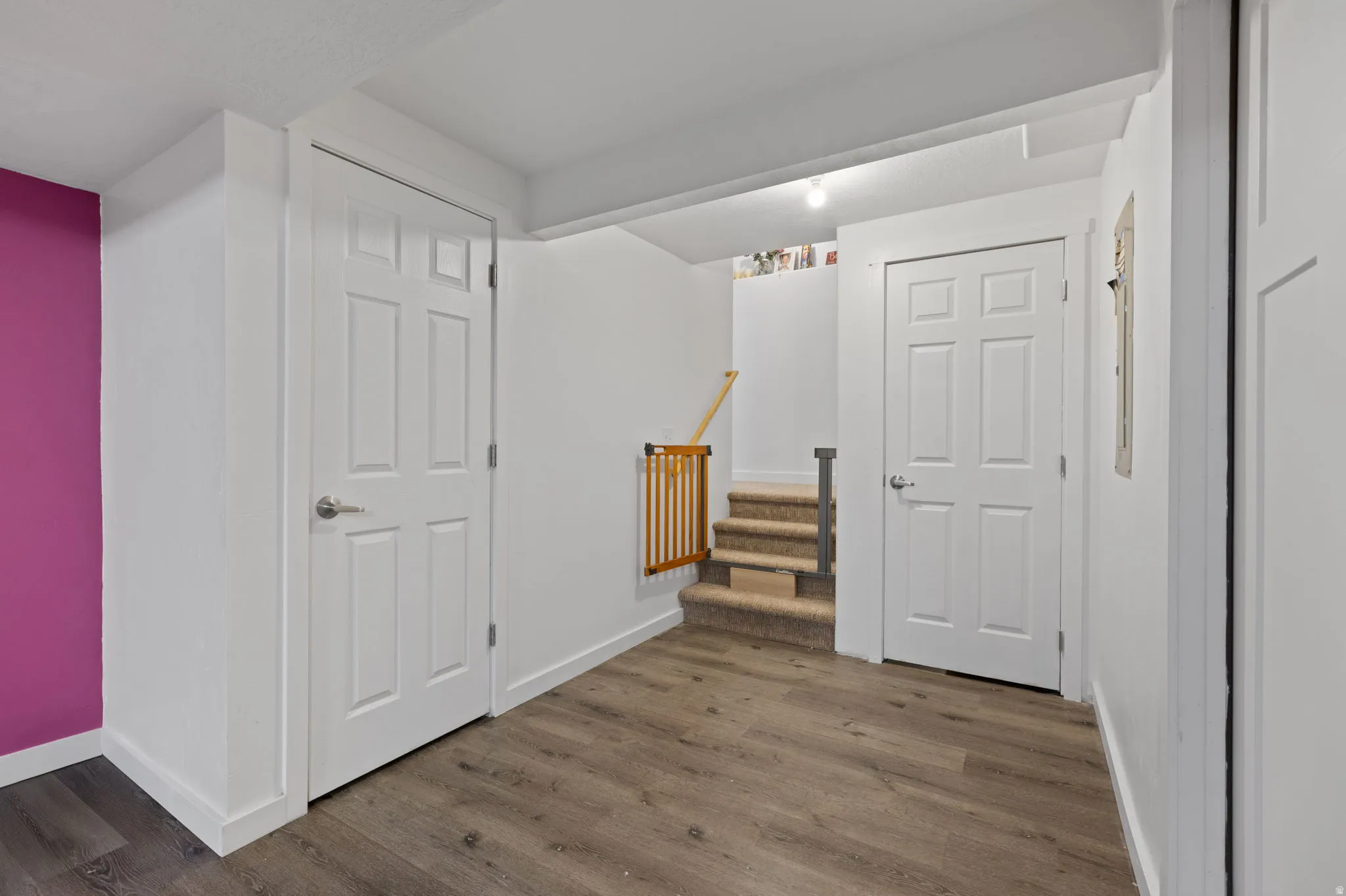 Wood-finish flooring throughout, featuring crisp white trim and solid interior doors