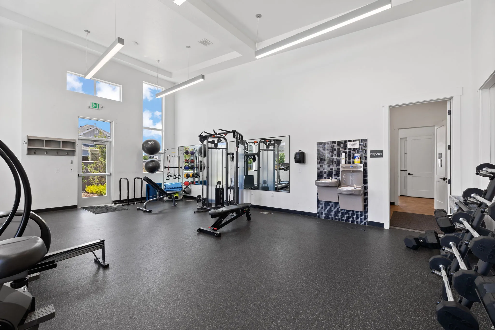 Fitness center with high ceilings and tall windows