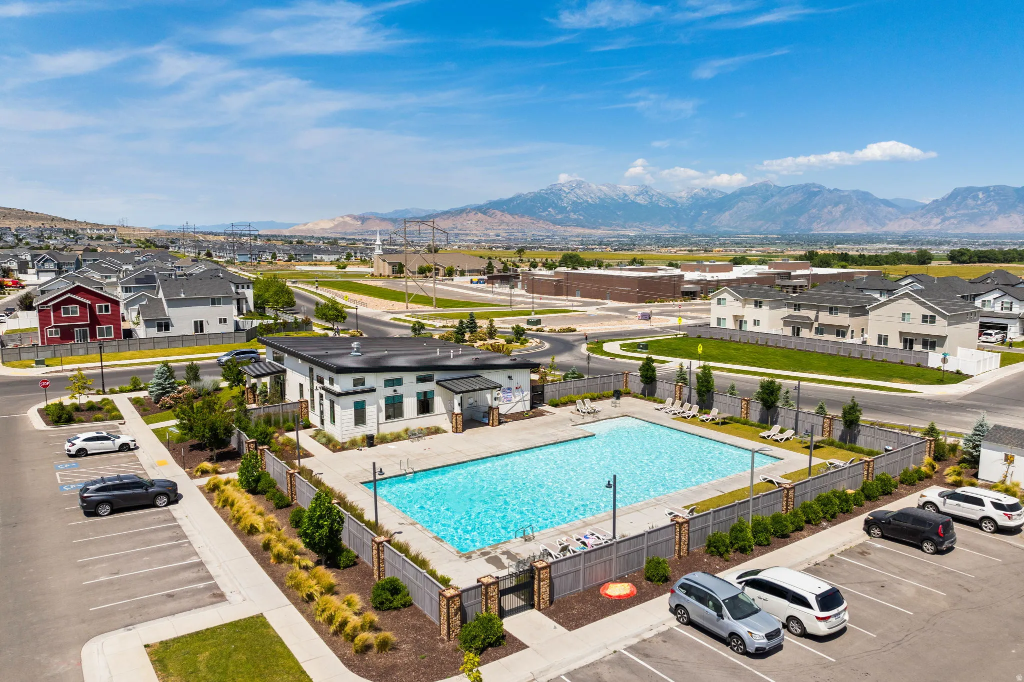 Community clubhouse featuring a rectangular swimming pool, surrounding lounge area, and mountain backdrop