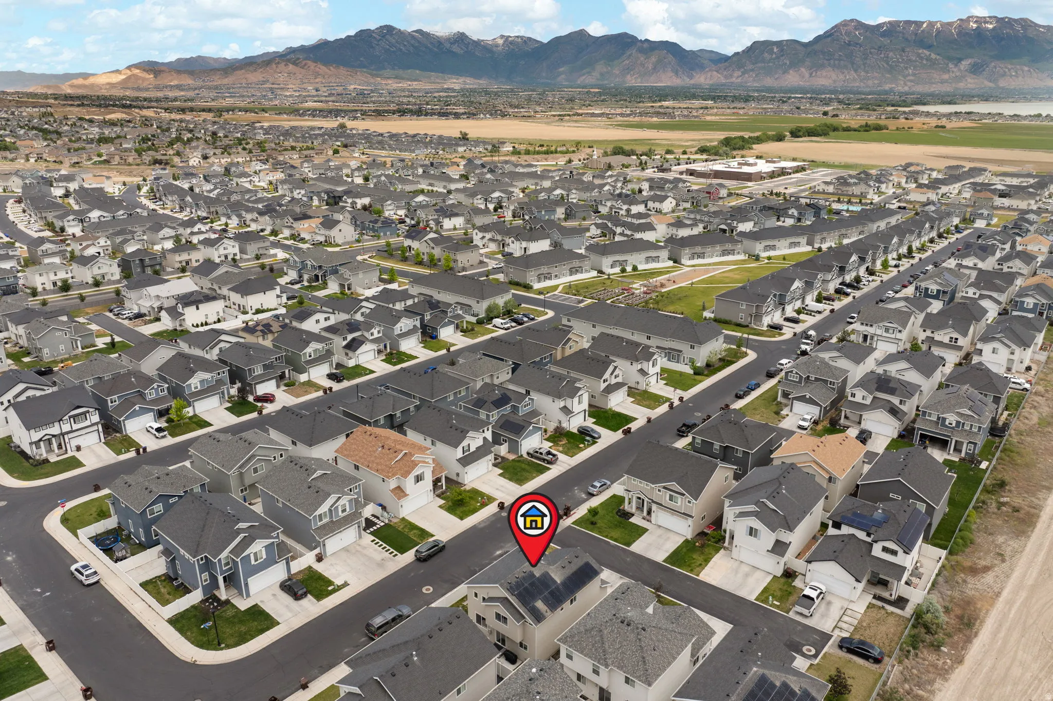 Aerial perspective showcasing a residential neighborhood with distant mountains and a body of water