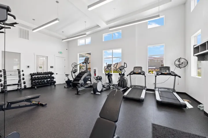 Fitness center featuring ample space, rubber flooring, and high ceilings with recessed linear lighting