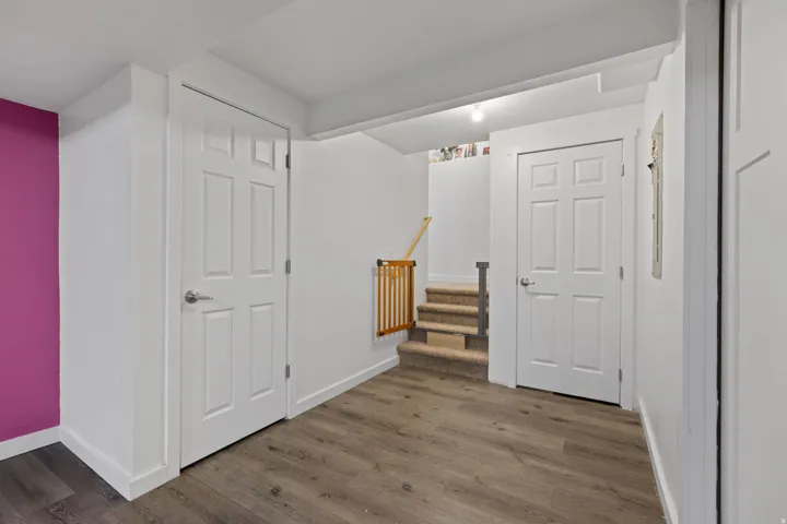 Wood-finish flooring throughout, featuring crisp white trim and solid interior doors