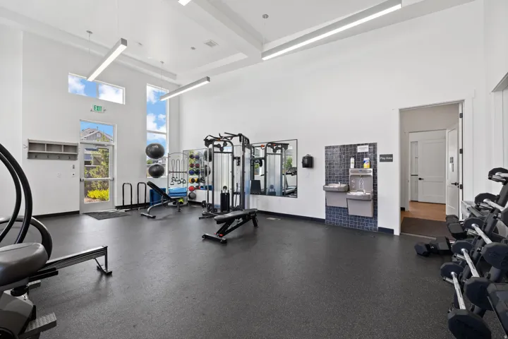 Fitness center with high ceilings and tall windows