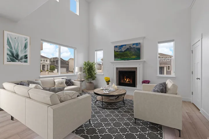 Spacious living area featuring high vaulted ceilings, large windows, a built-in fireplace with a stone surround, and light wood-finish flooring