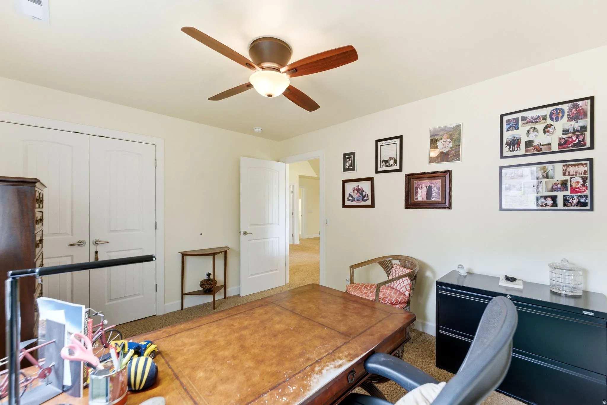 Room featuring a ceiling fan with integrated lighting, neutral-toned walls, and carpet flooring