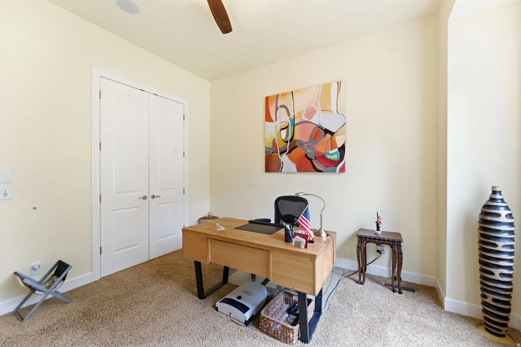 Carpeted room with double panel doors, an in-ceiling speaker, and a ceiling fan