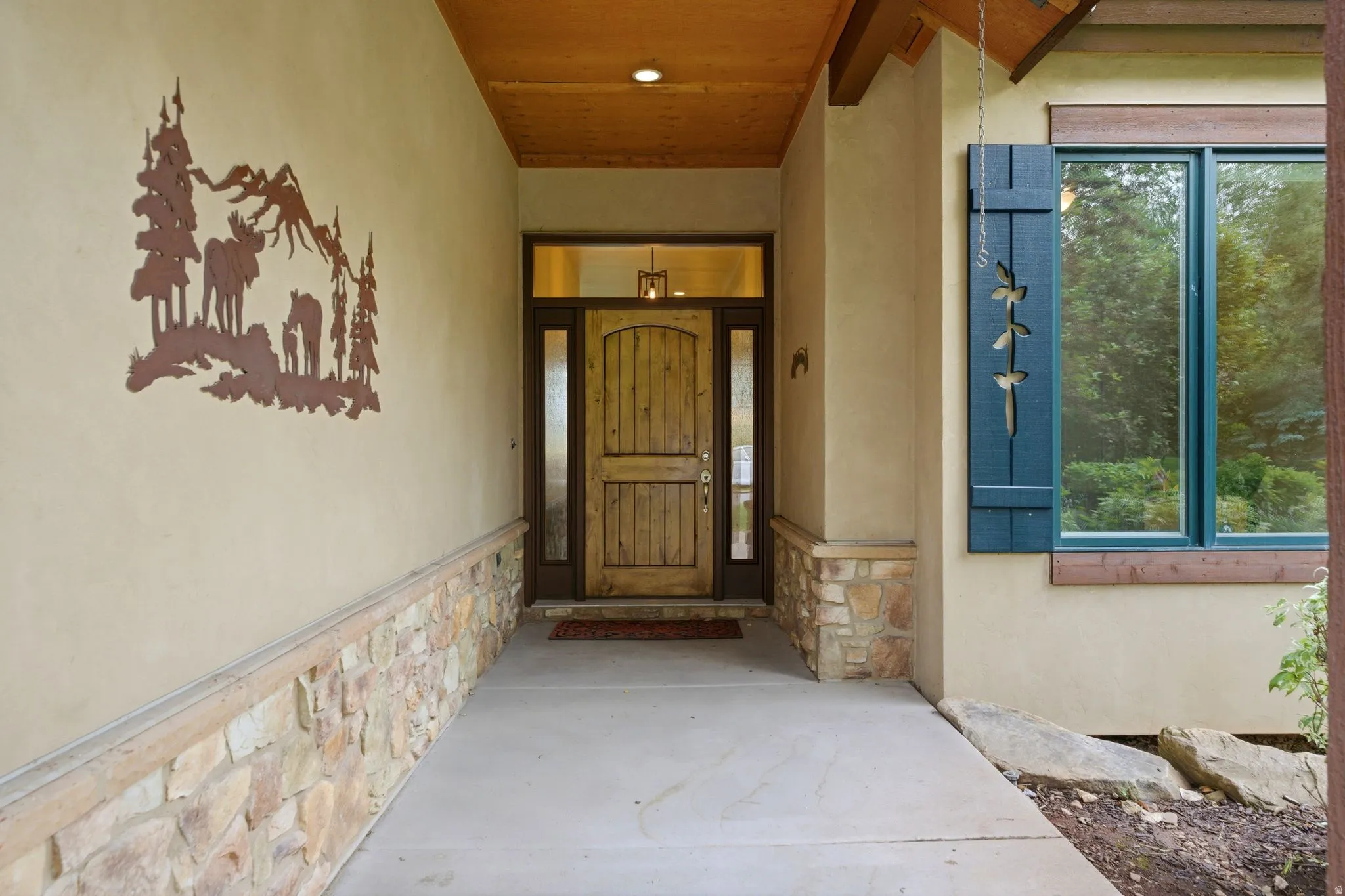 Inviting entry with a solid wood door flanked by sidelight windows and a transom