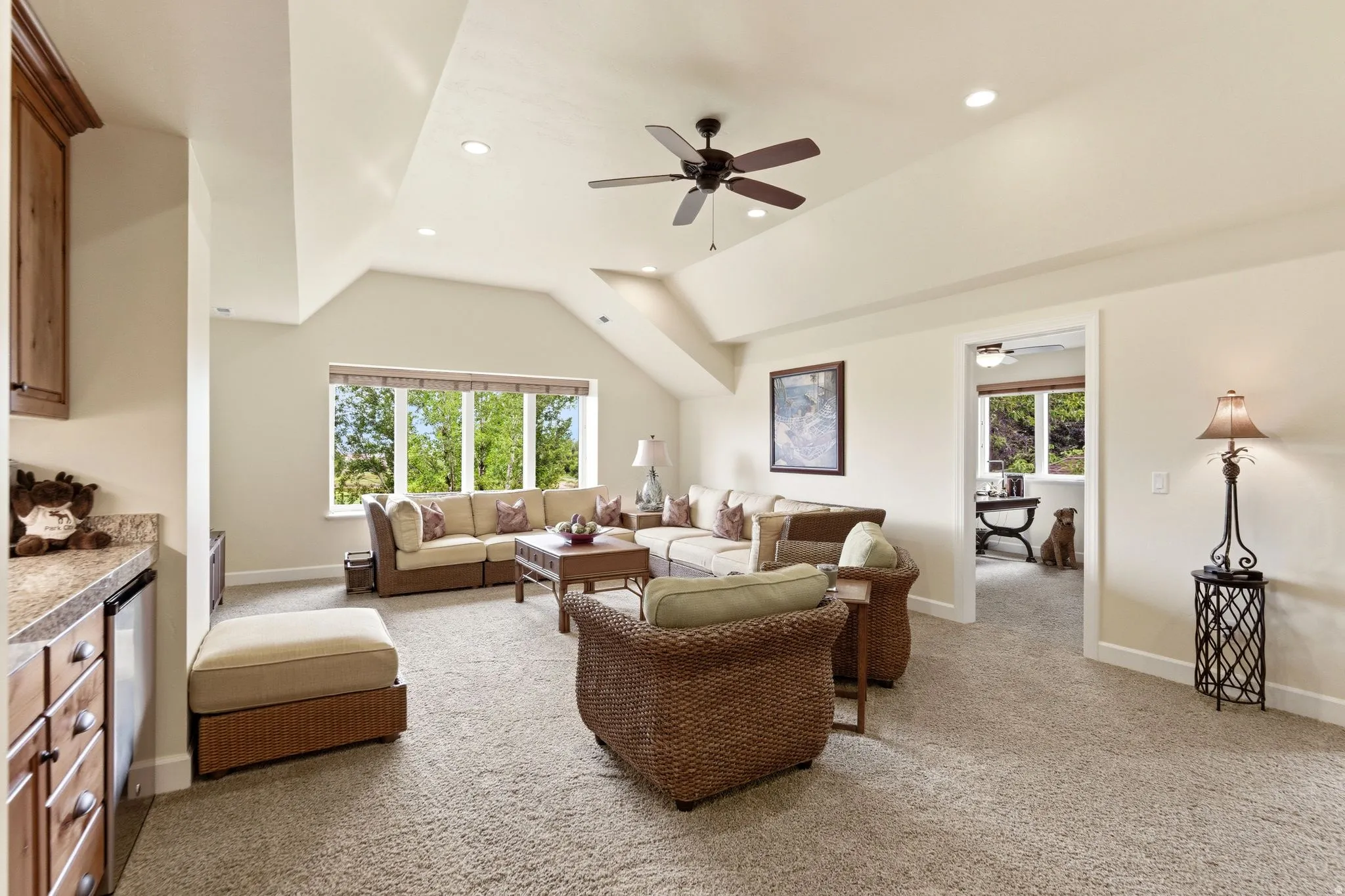 Spacious living area featuring vaulted ceilings, recessed lighting, and a ceiling fan