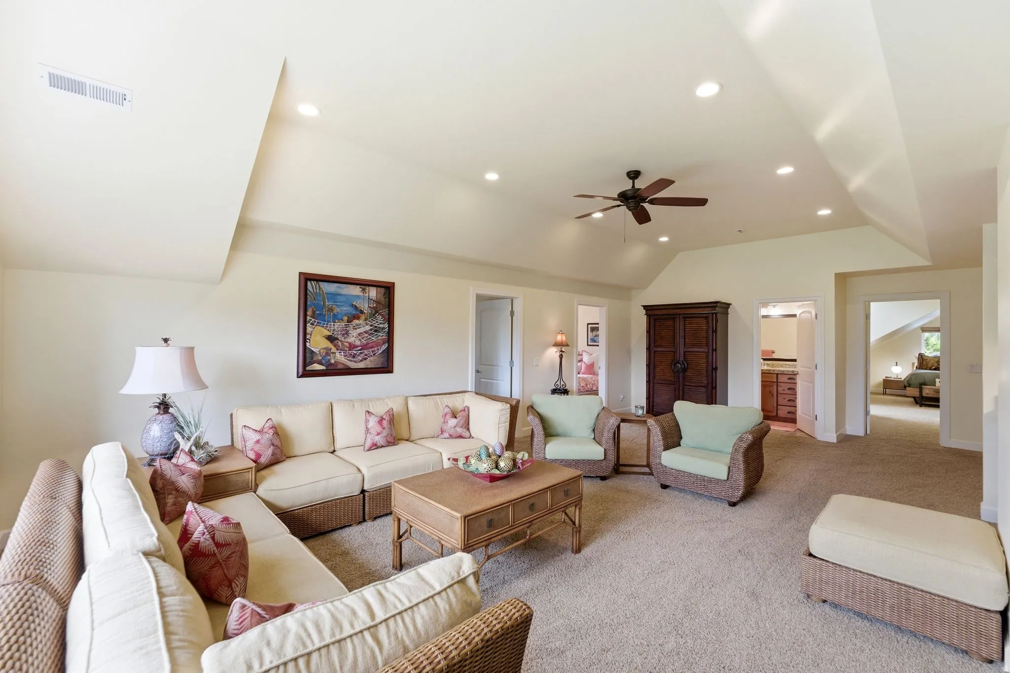 Spacious living area featuring vaulted ceilings, recessed lighting, ceiling fan, and carpet flooring