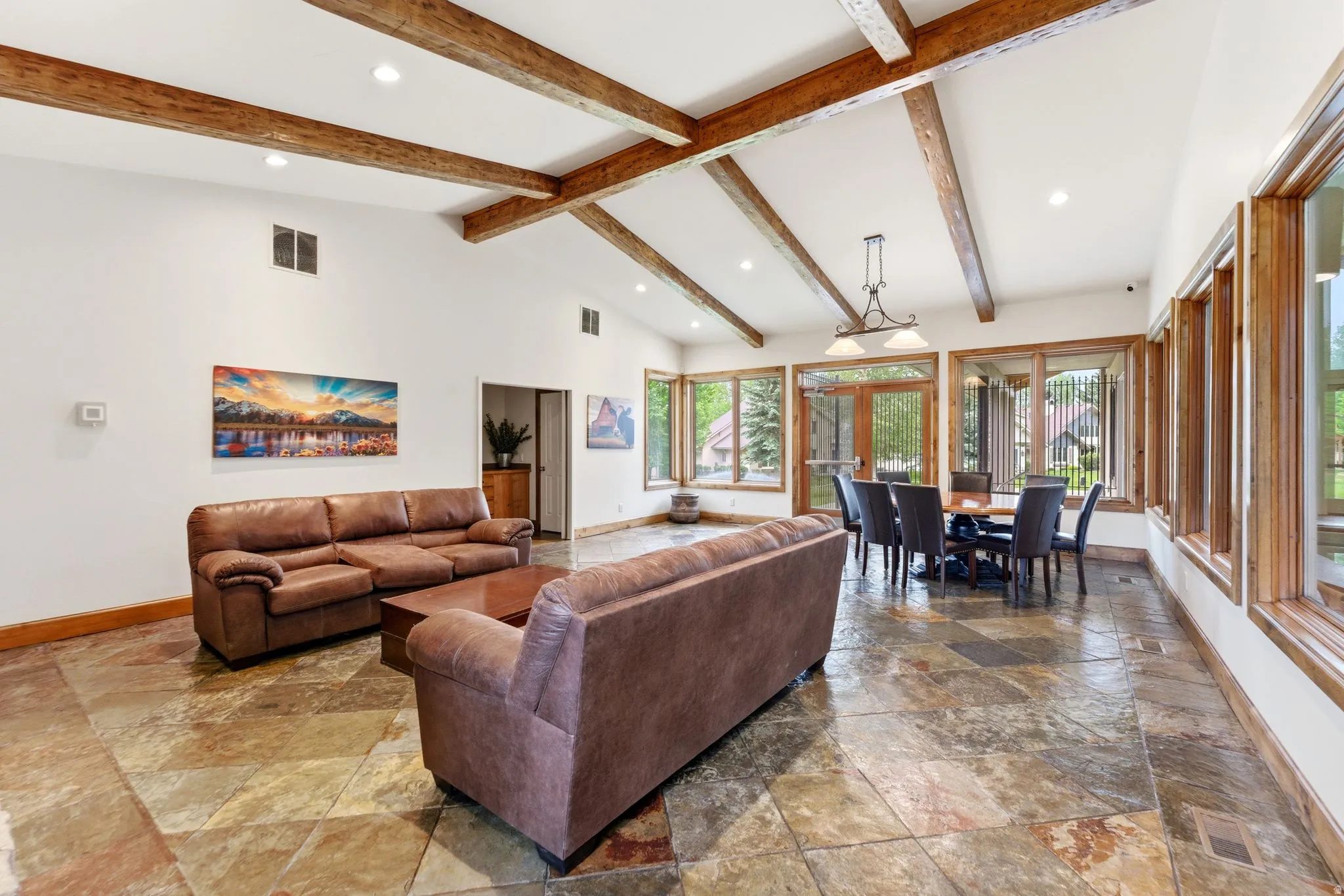 2nd clubhouse Open-concept room featuring vaulted ceilings with exposed wood beams, recessed lighting, and large multi-pane windows with wood frames
