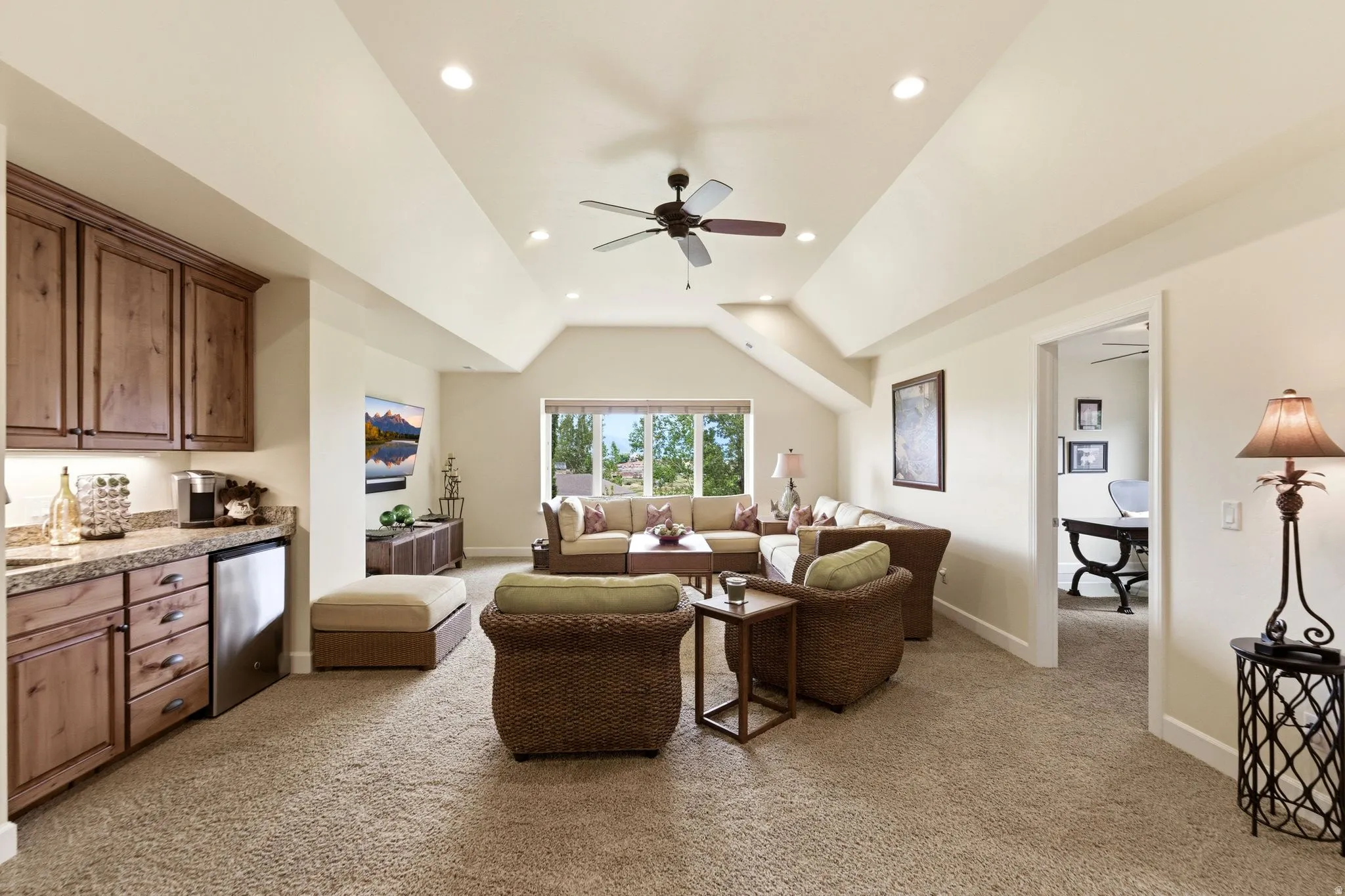 Spacious room featuring vaulted ceilings, recessed lighting, and a ceiling fan