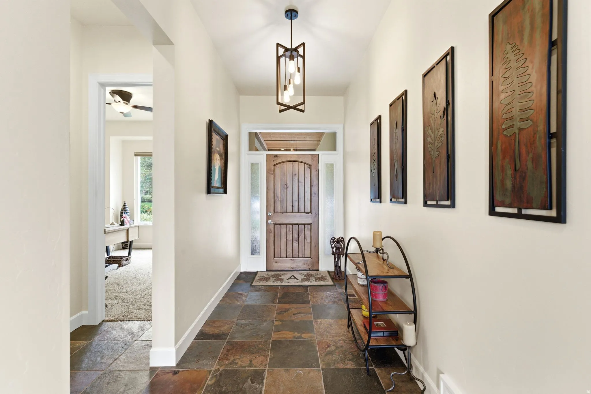 Foyer featuring a wood-panel entry door with sidelights, a coffered ceiling detail, and slate tile flooring