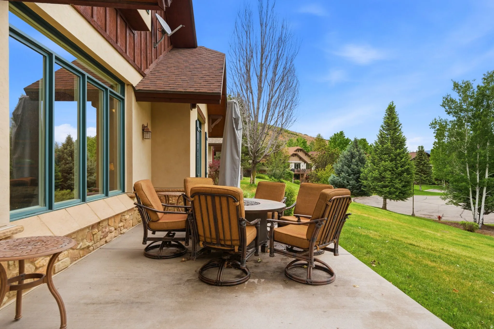 Expansive concrete patio area with a stone base and stucco exterior