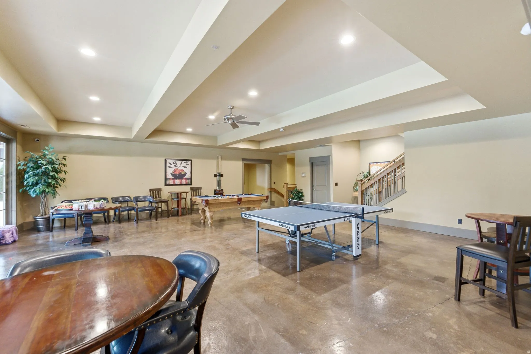 Spacious recreation room featuring concrete flooring, recessed lighting, and a ceiling fan