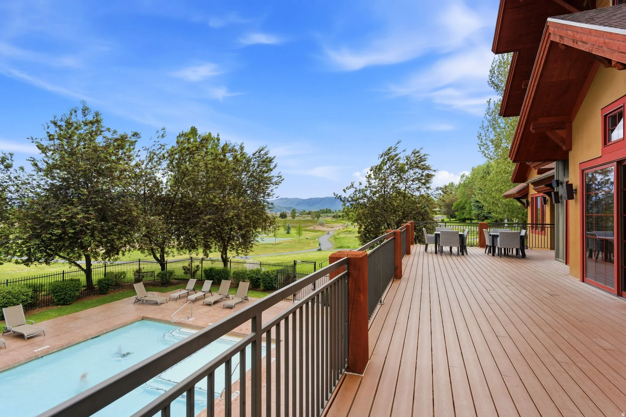 Expansive outdoor deck featuring wood-finish flooring and a metal railing