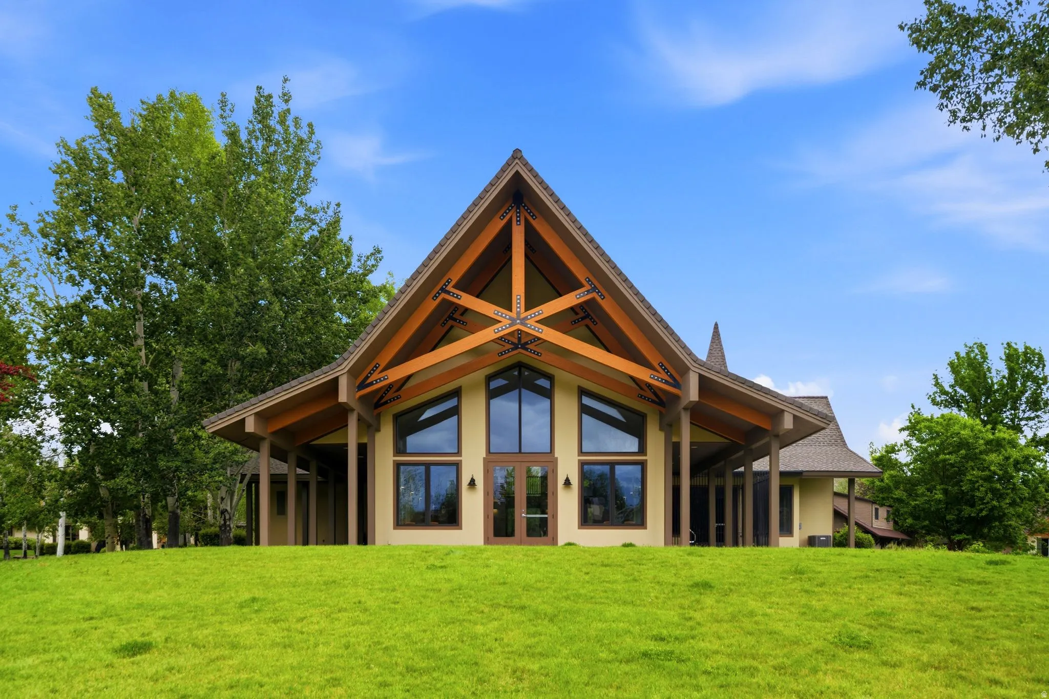 2nd clubhouse Contemporary architecture featuring a soaring A-frame roofline with exposed timber trusses and expansive glass windows