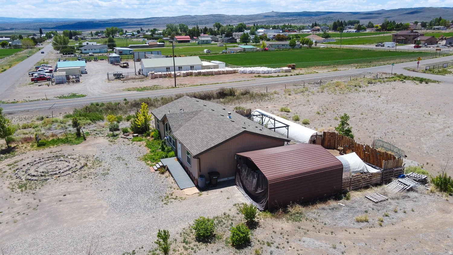 Single-story property featuring a composite shingle roof and a spacious gravel lot