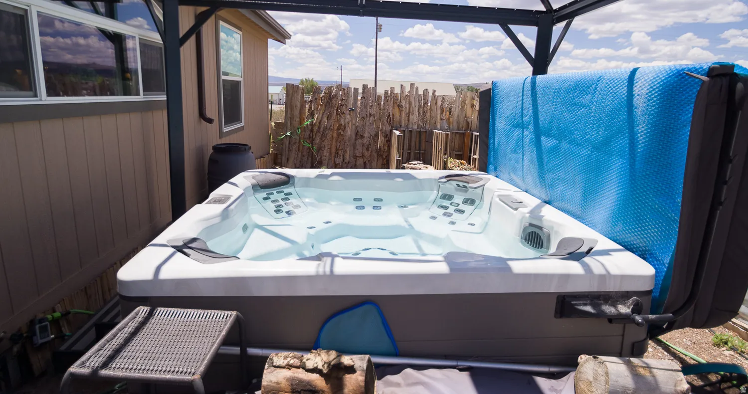 Outdoor spa with multiple jets, integrated seating, and a protective cover