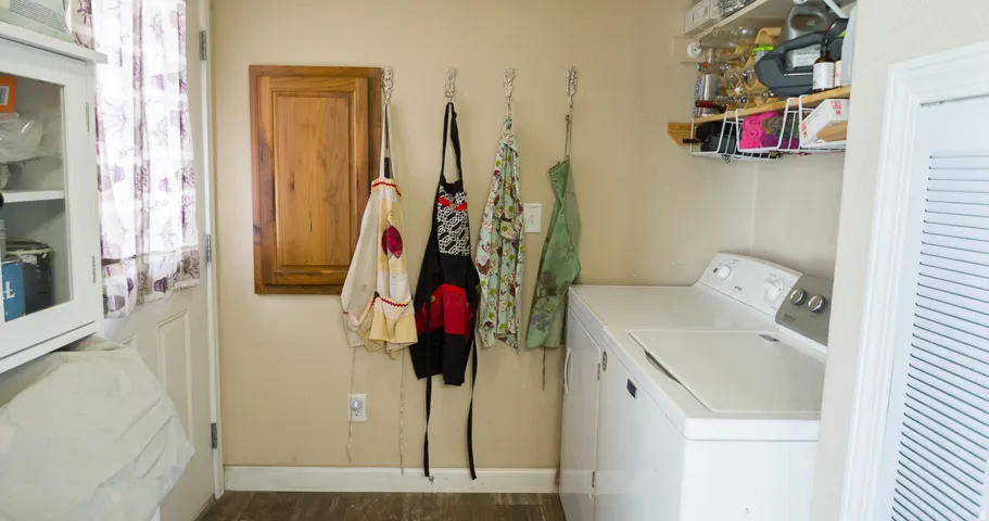 Laundry area featuring wood-finish flooring and neutral wall tones