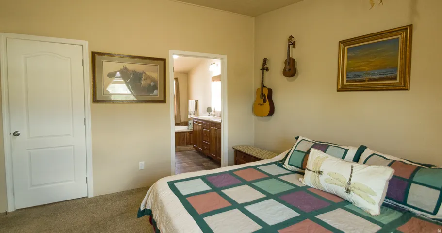 Carpeted bedroom with a flat ceiling and light-toned walls