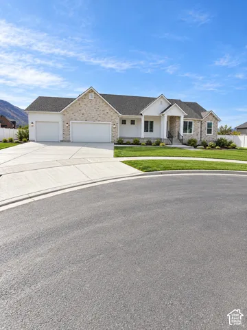 Single-story exterior featuring stone veneer siding, horizontal lap siding accents, a three-car garage, and a covered front porch entry