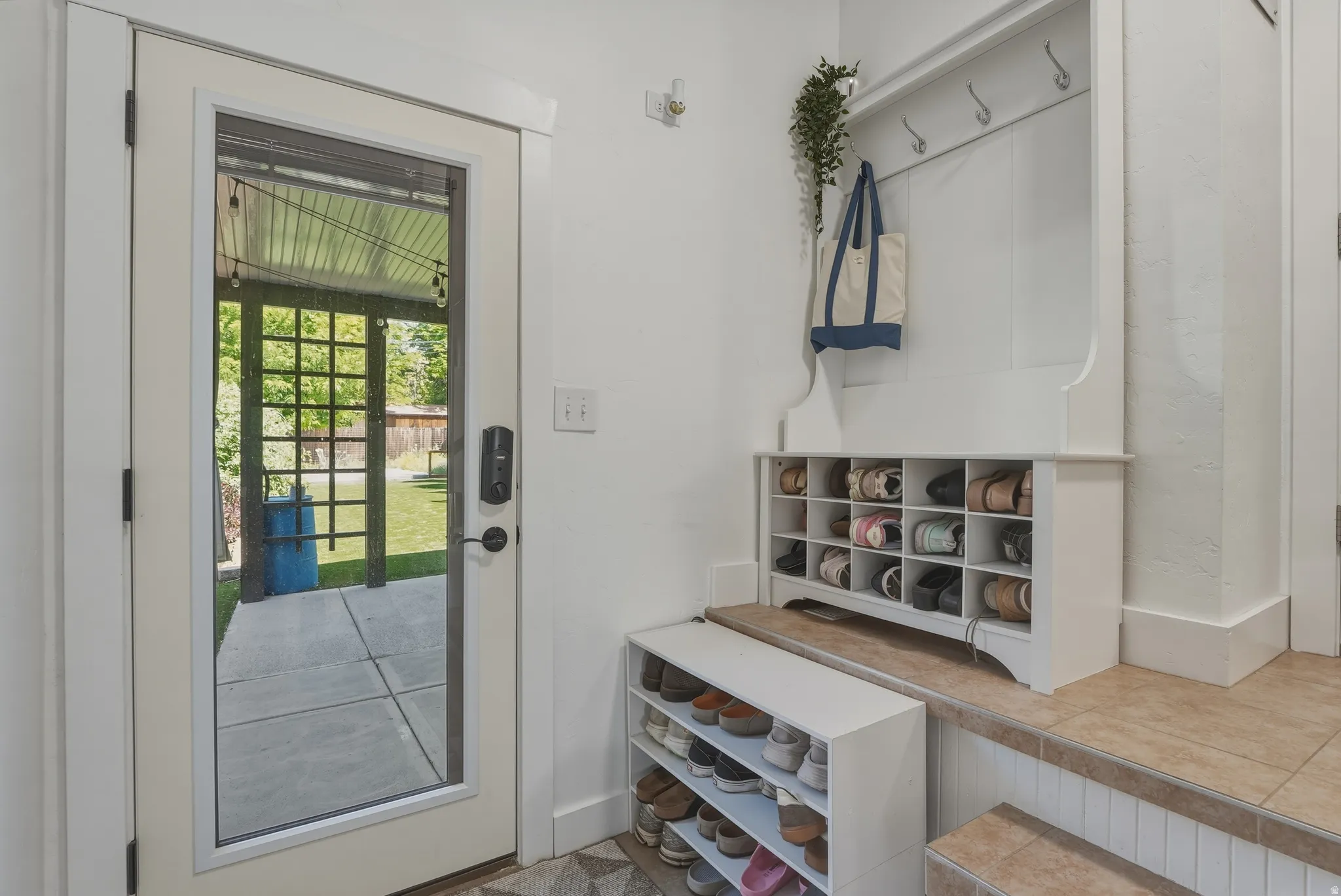 Full-lite door offering outdoor access to a covered patio and green space
