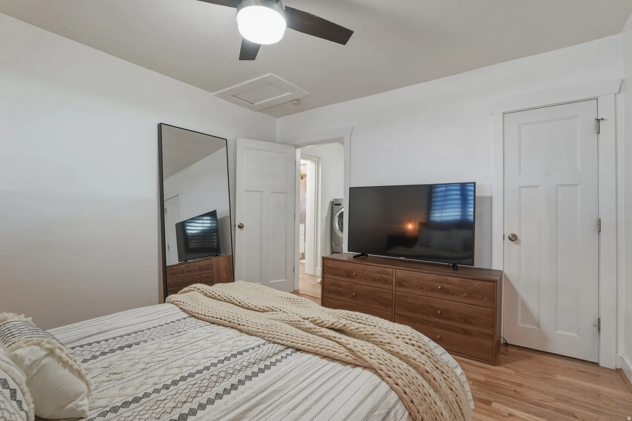 Bright room featuring wood-finish flooring and a ceiling fan with integrated lighting