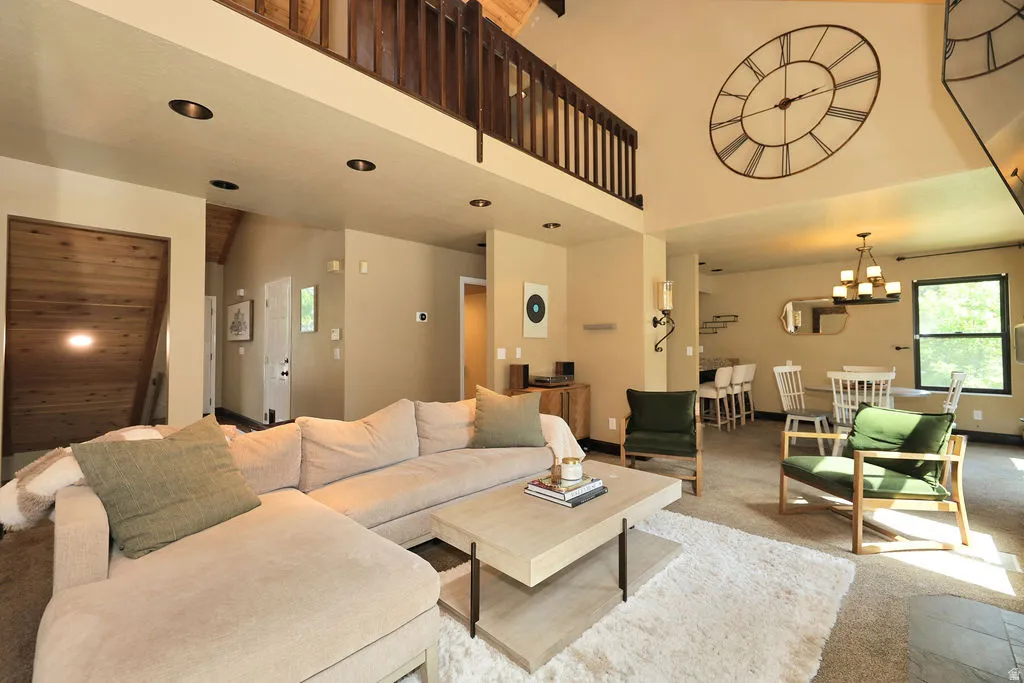 Spacious living area featuring a high vaulted ceiling, recessed lighting, and a second-story interior balcony with wood railing