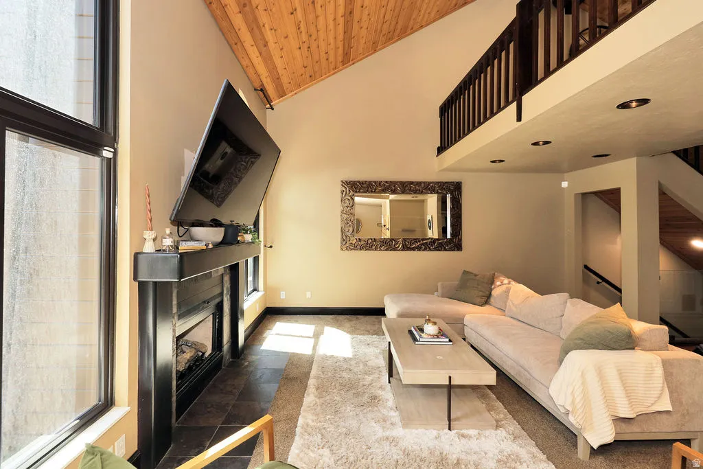 Vaulted wood-finish ceiling over a living area with a fireplace and large windows