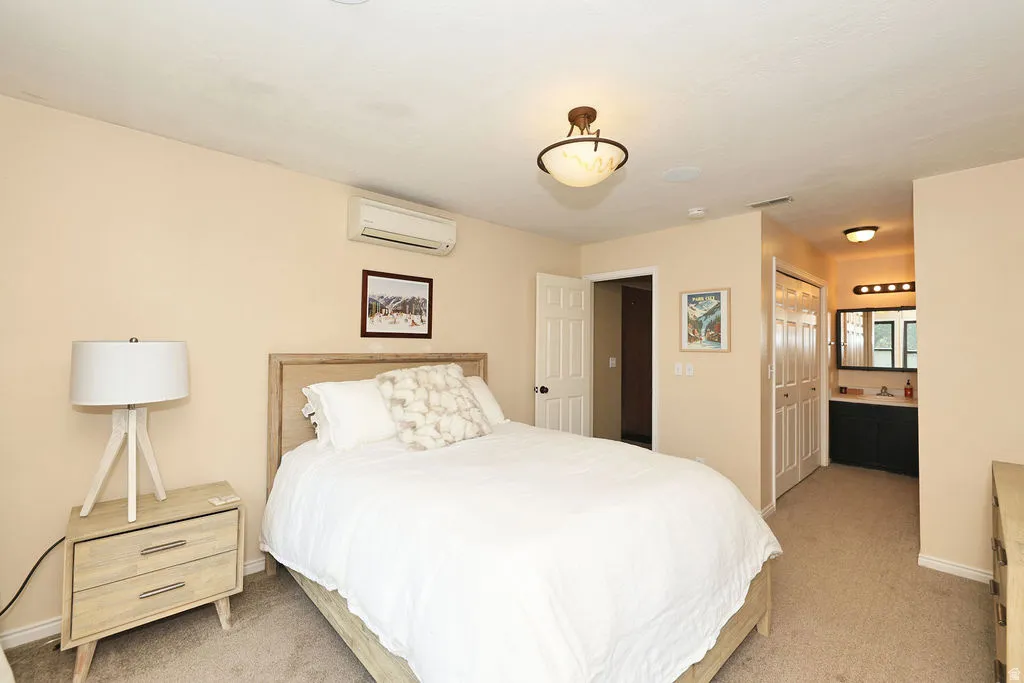 2nd floor primary bedroom featuring a light-toned wood headboard, ceiling-mounted light fixture, and wall-mounted air conditioning unit