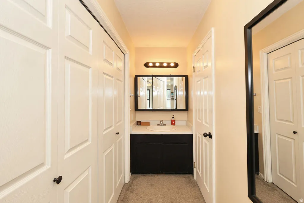 upstiars primary Vanity area featuring a built-in sink, dark wood-finish cabinetry, and a framed mirror