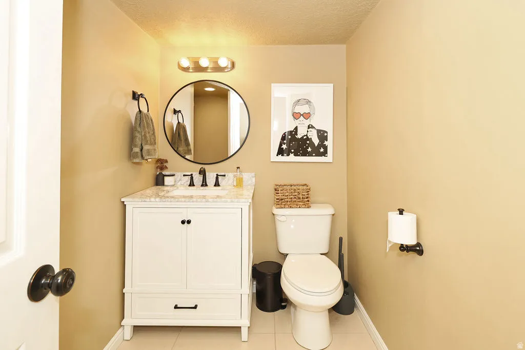 first floor bath off kitchen. White vanity with a stone-finish countertop and undermount sink