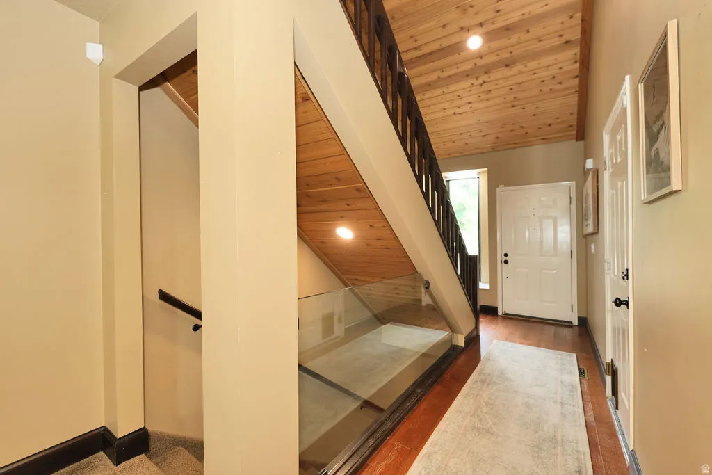 Entryway featuring wood-finish flooring, a paneled front door, and a wood-paneled ceiling